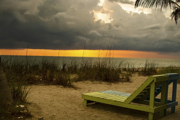 Empty recliner facing beach sunset